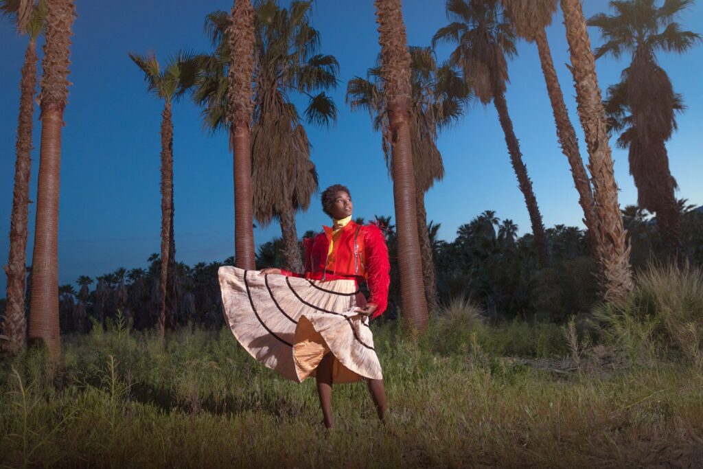 Quirk editorial styling with a pink skirt and red top outdoors