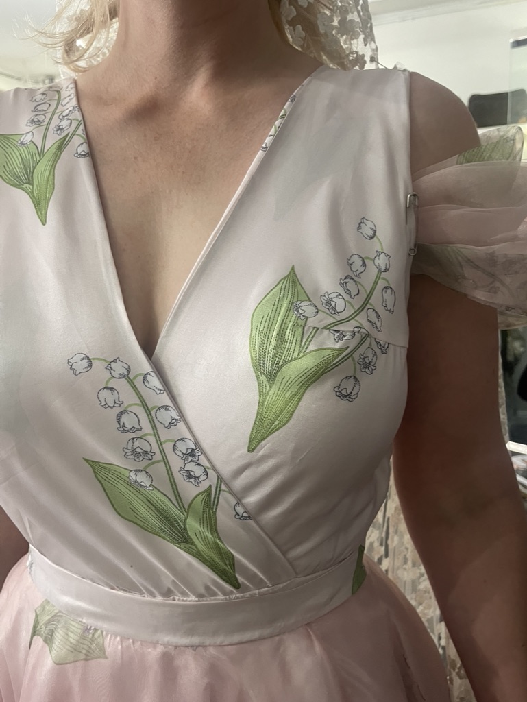 Detail inset — lily-of-the-valley motifs and bodice construction.