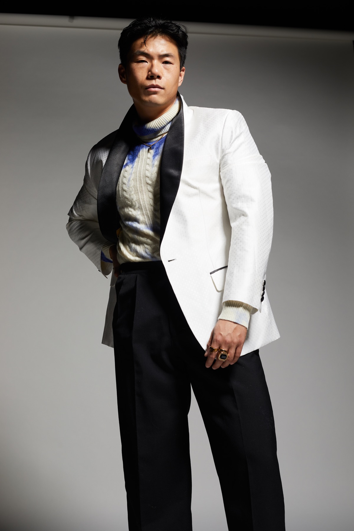 Closer view of the jacket’s black lapels, patterned white fabric and contrasting pocket trim