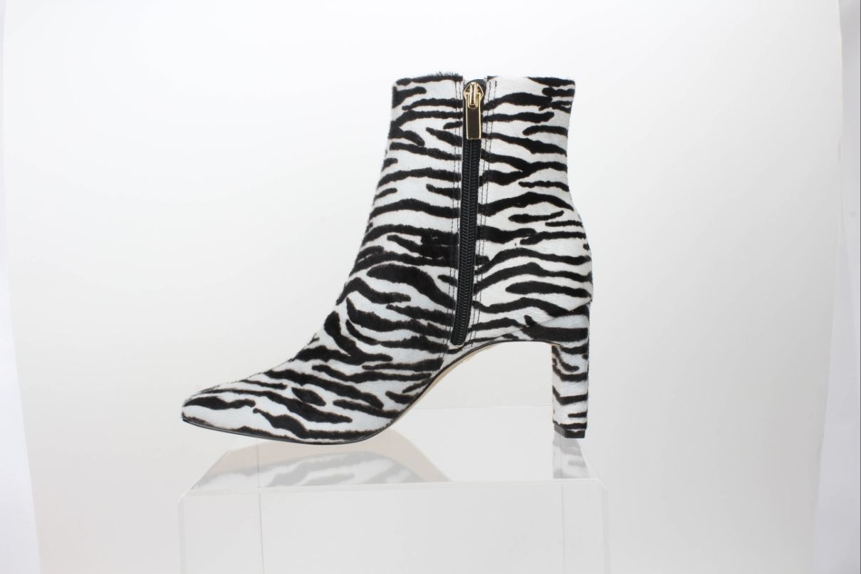 Inner side profile of a Carrano black-and-white zebra-print calf-hair ankle boot with a square toe and gold-tone zipper pull.