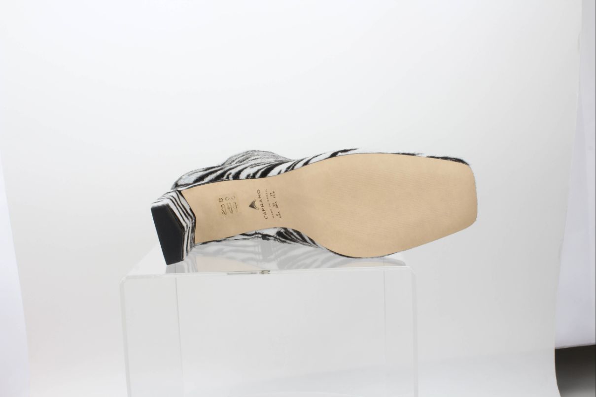 Sole view of a Carrano zebra-print ankle boot, showing the Carrano markings, smooth tan outsole and black heel tip.