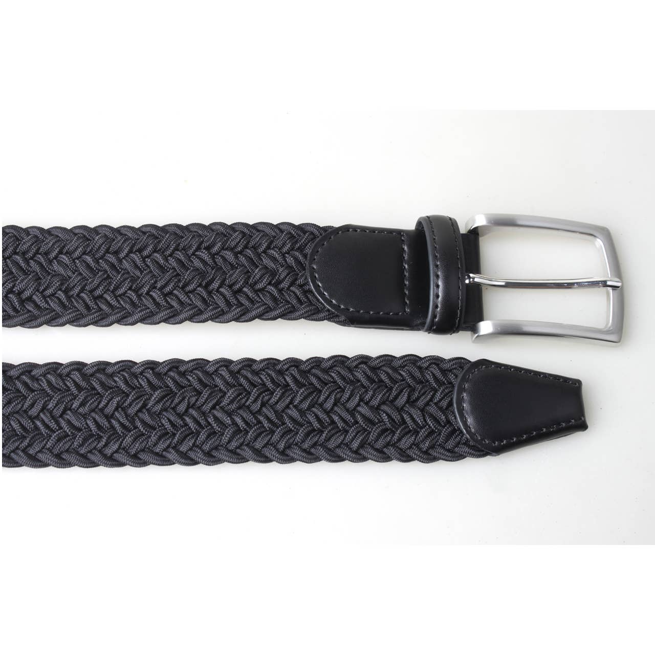 Black PX belt laid on white to show its leather buckle end, tapered tip and braided stretch body.