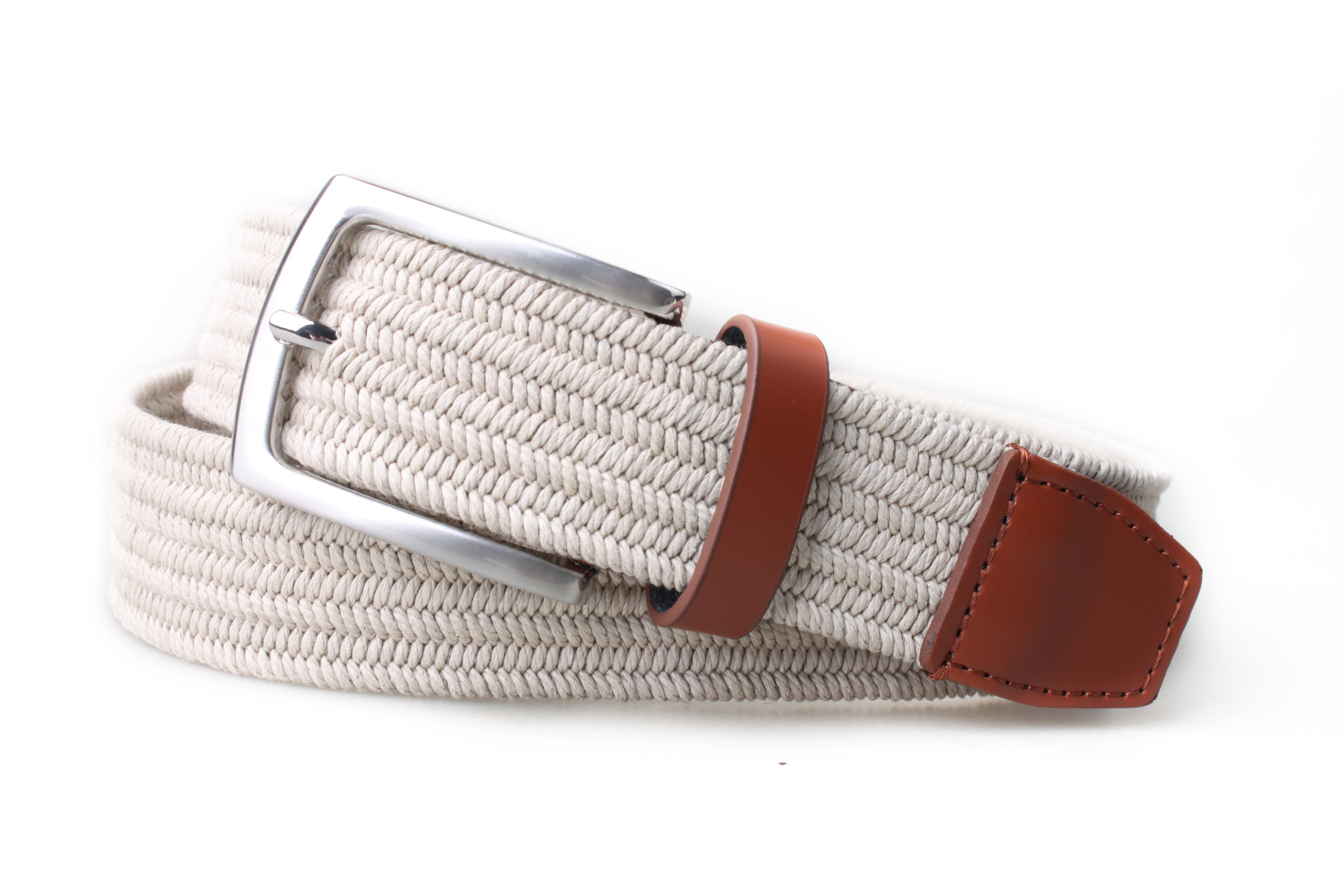 PX beige woven stretch belt coiled from the opposite angle, with brown leather keeper and stitched tip beside a satin nickel-finish buckle.