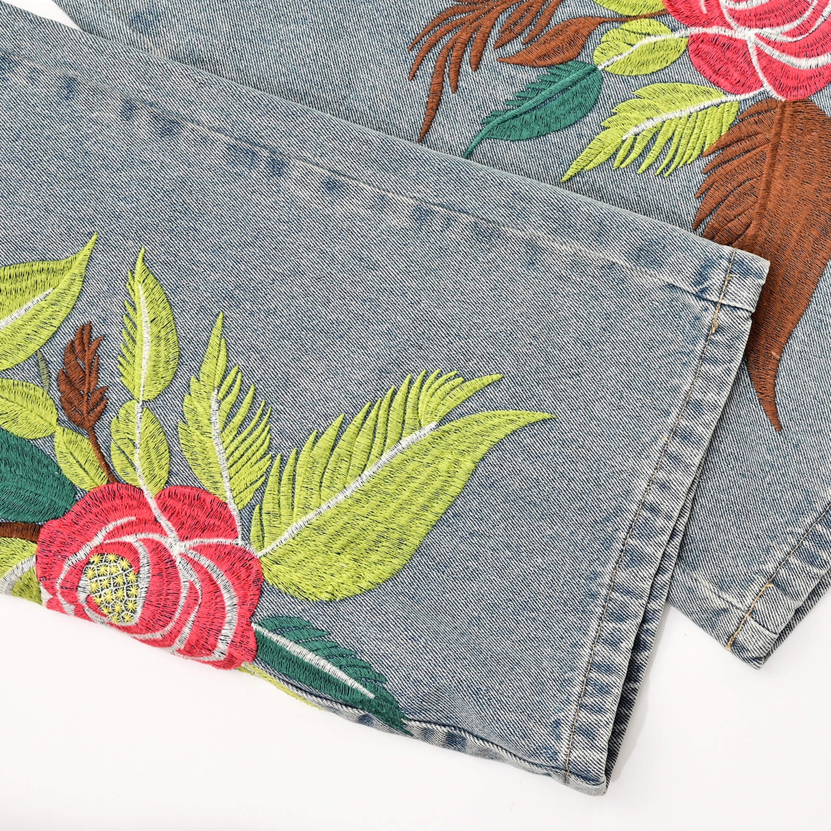 Turned lower legs showing stitched hems and pink blossom and green leaf embroidery on Sakura denim.