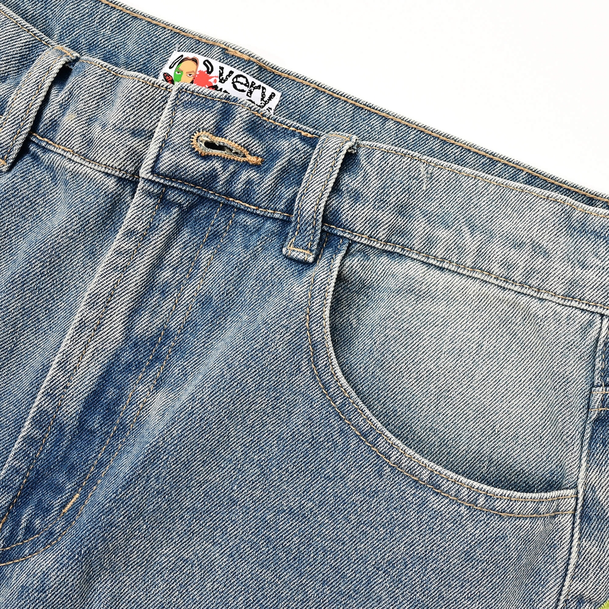 Waistband and open buttonhole with a partial VERYRARE inner label on the Sakura denim pants.