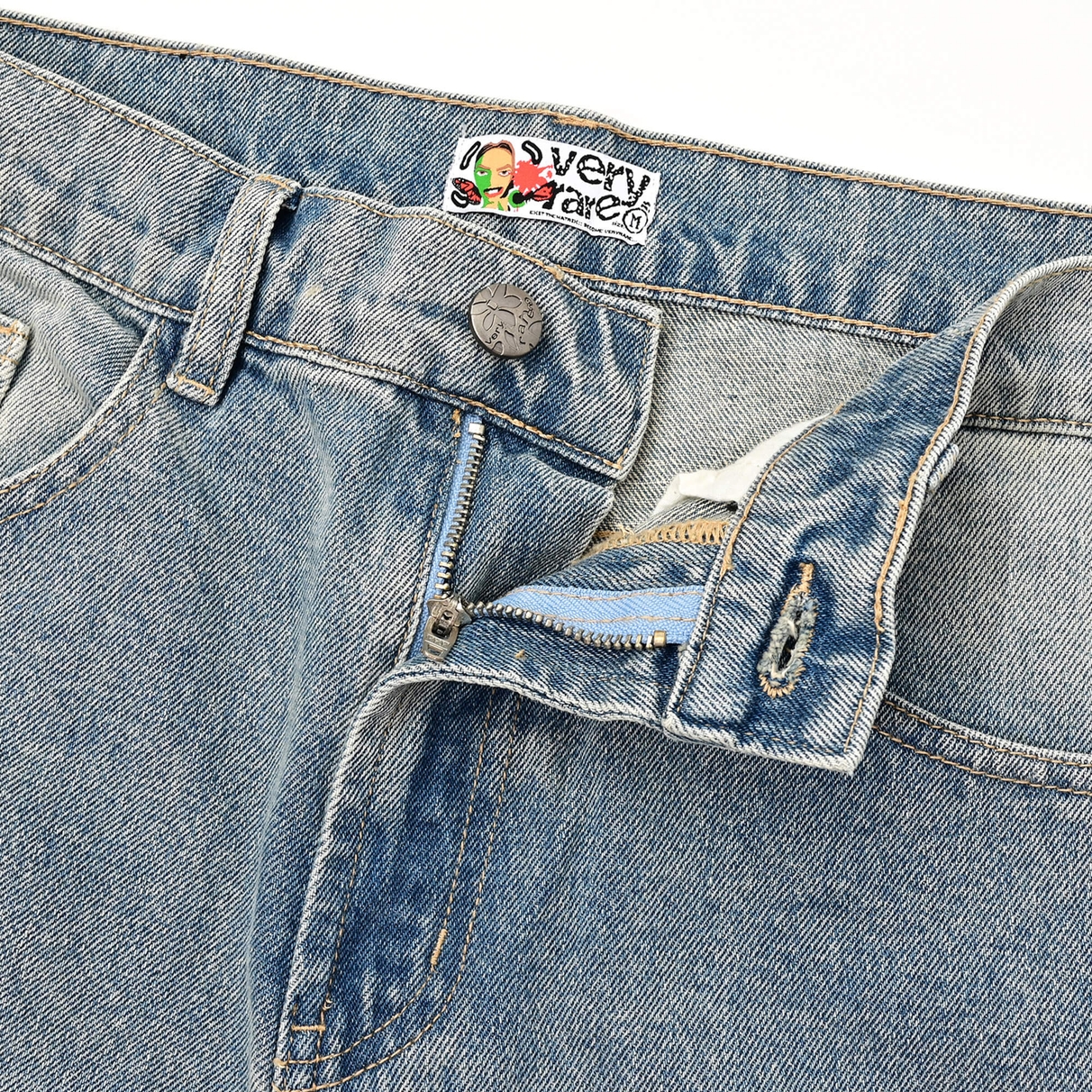 Open Sakura waistband showing the branded button, metal zip and inner label.