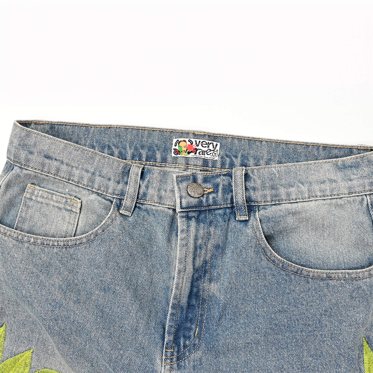 Closed front waistband and pockets showing the VERYRARE button and inner label on Sakura denim pants.