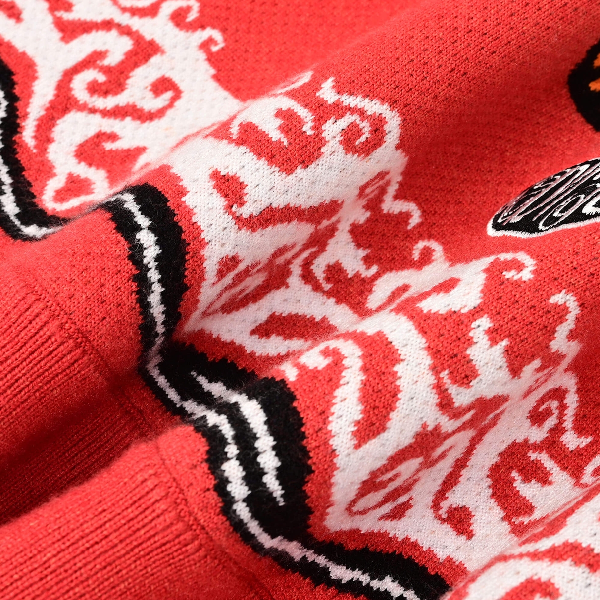 Close view of the Tiger Rug jacquard knit texture, patterned border and oval logo edge