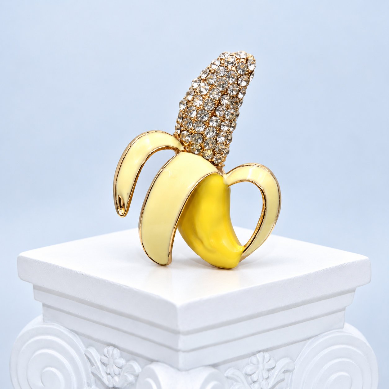 Close front view of the Mio Queena banana brooch showing curled ivory enamel peels, yellow enamel fruit and clear rhinestones