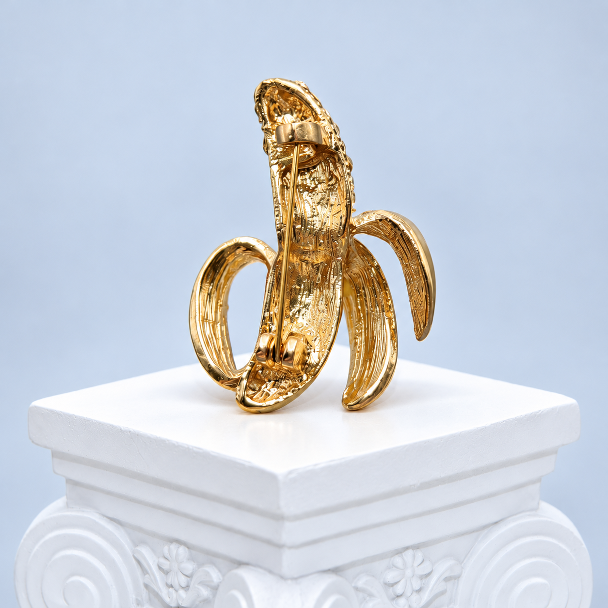 Reverse of the Mio Queena banana brooch showing its gold-tone metal back and vertical pin fastening