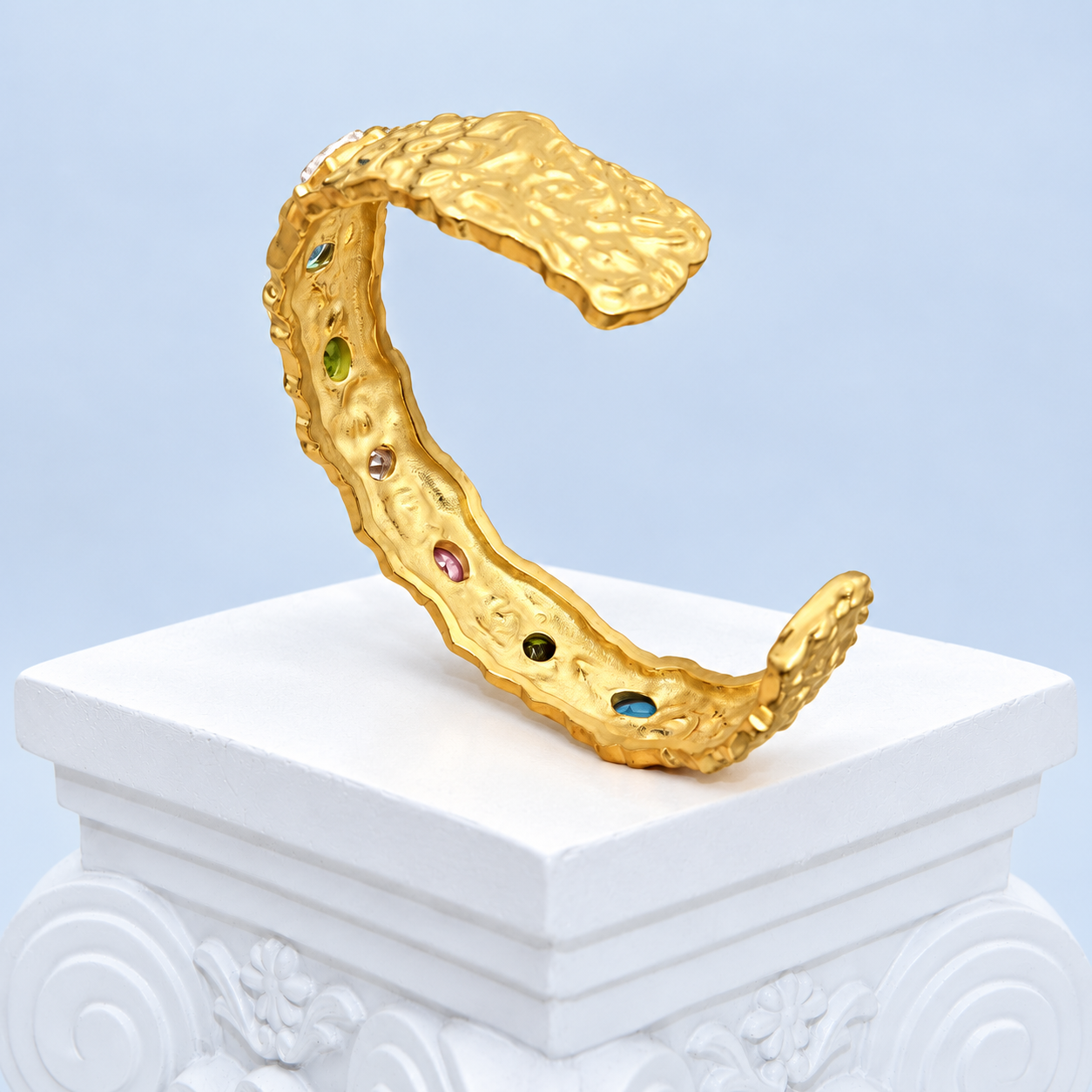 Interior reverse of the Mio Queena colored zircon cuff showing the open band and small apertures behind the stone settings