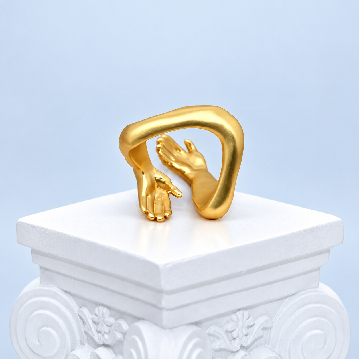 Rear view of the Mio Queena Embrace ring showing the curved band and backs of the sculpted hands