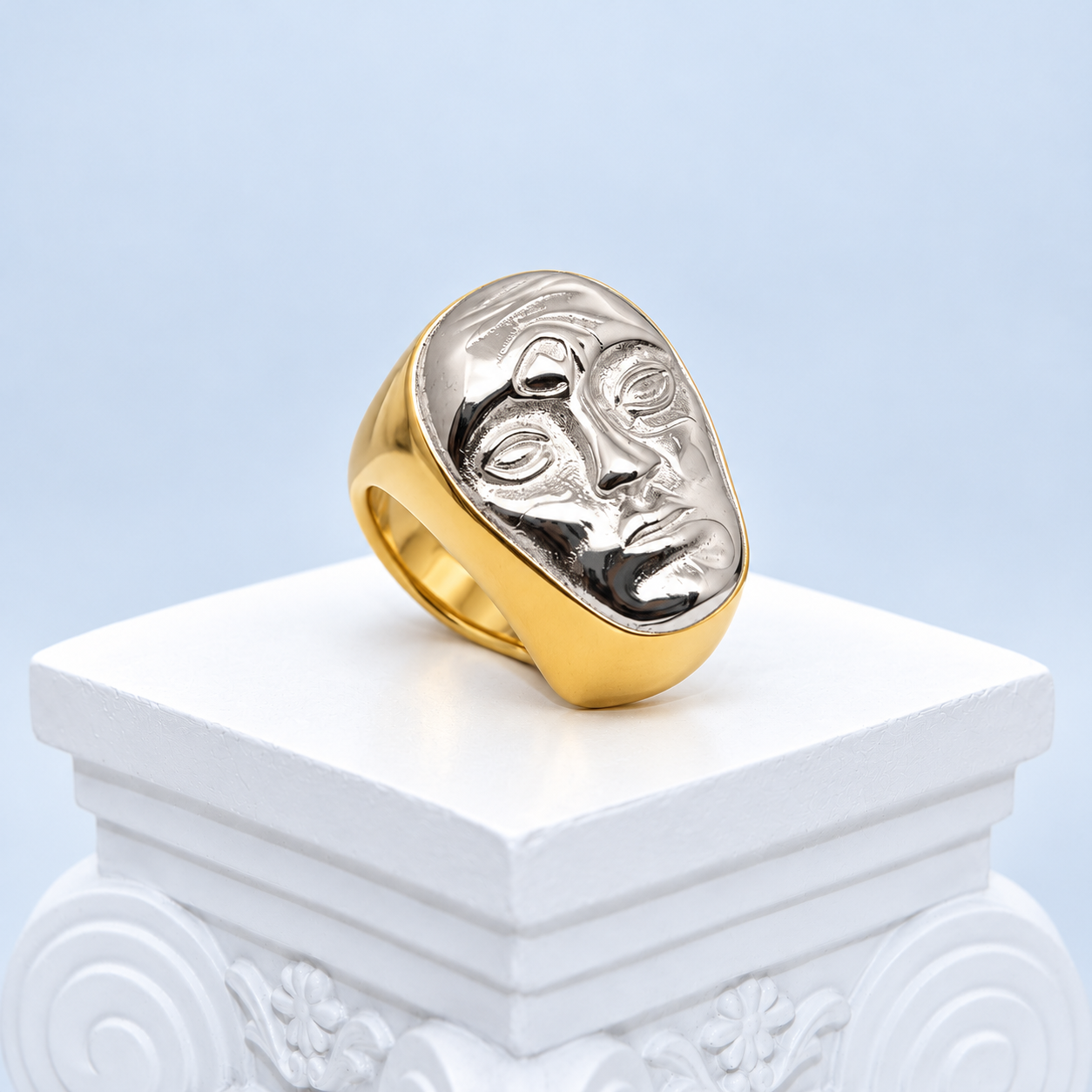 Oblique front detail of the Mio Queena face ring showing asymmetric sculpted eyes, nose and lips in a silver-tone finish