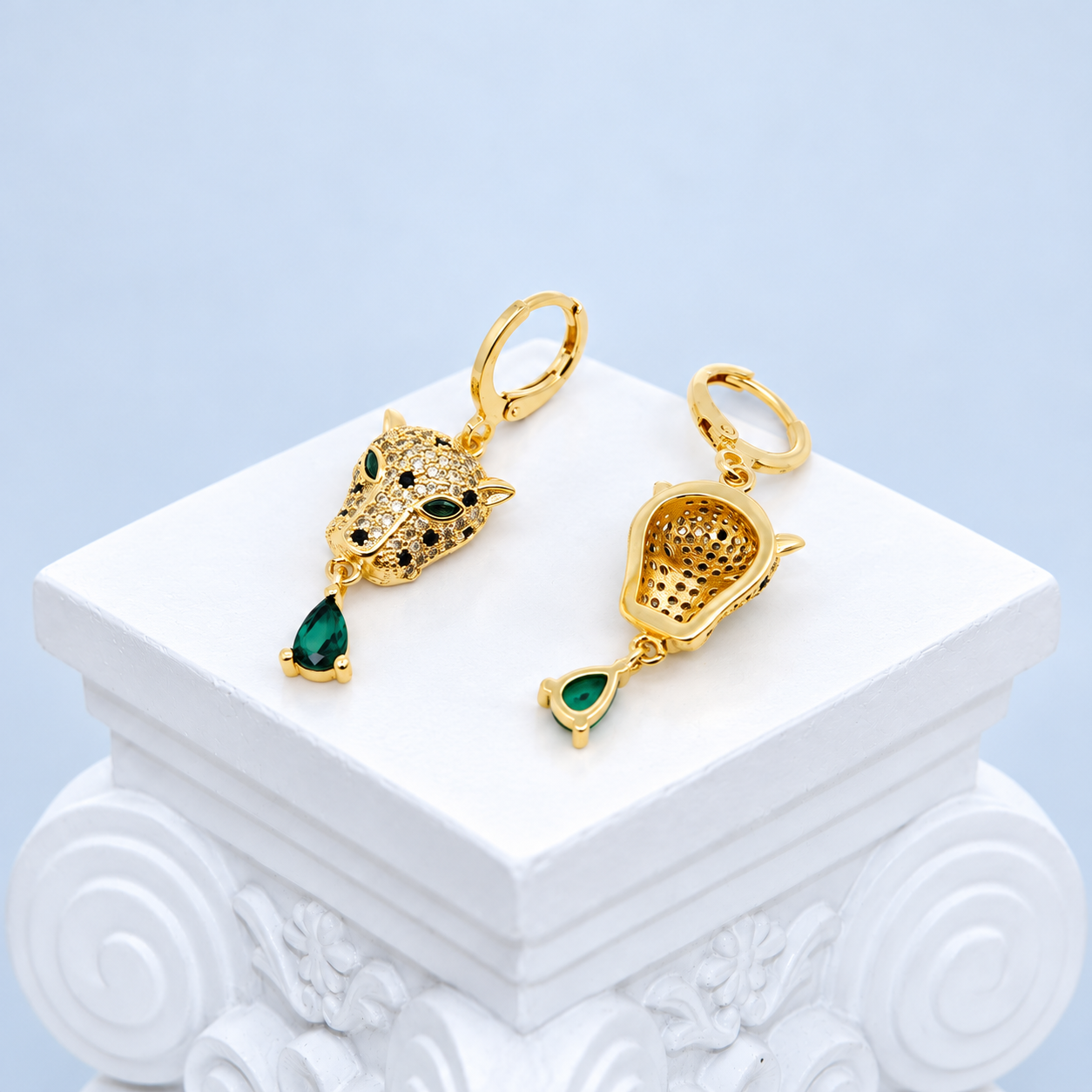 Front and back of the Mio Queena leopard earrings showing the perforated reverse and green teardrop settings
