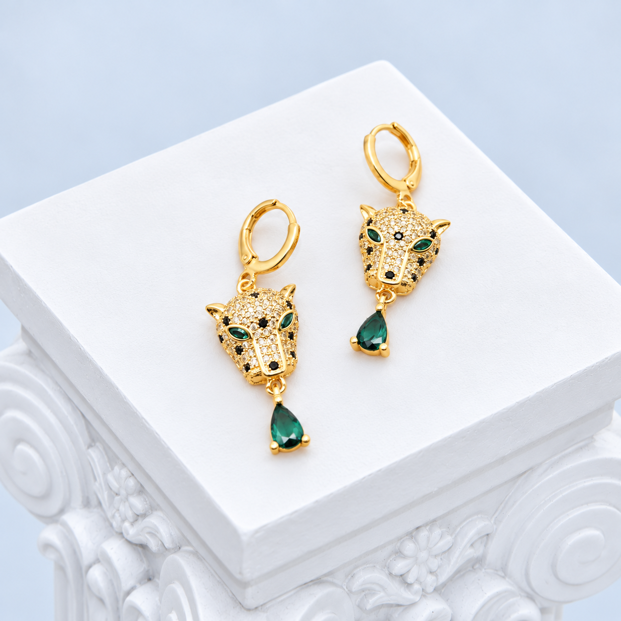Oblique view of both Mio Queena leopard earrings showing pavé faces, dark spots and hinged gold-plated hoops