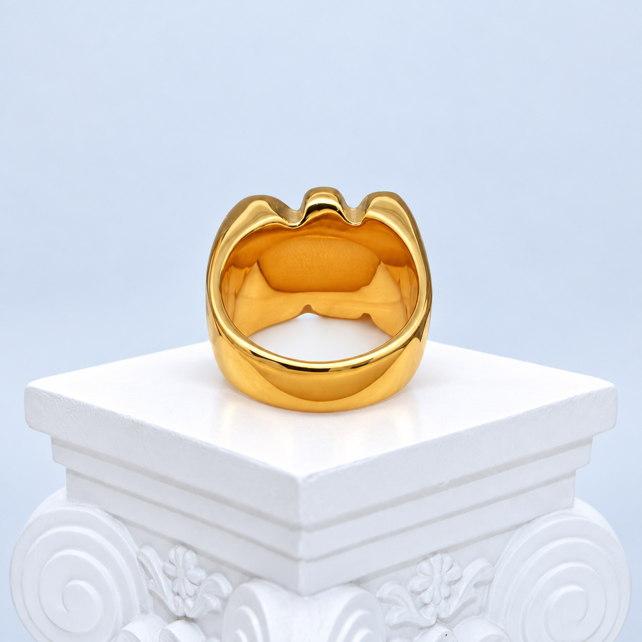 Back and interior view of the Mio Queena gold-plated NO ring on a white studio pedestal, showing the smooth closed band and tapered shoulders.