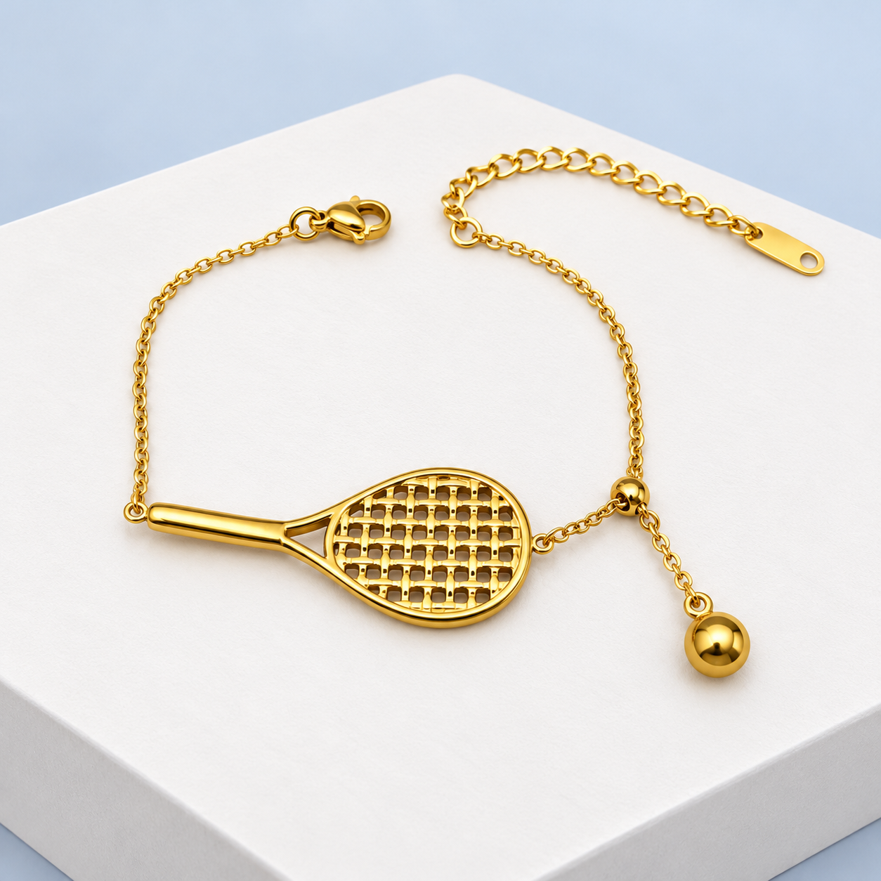 Whole reverse view of Mio Queena tennis racquet bracelet showing the plain gold-plated handle and ball backs, chain, clasp and extender.